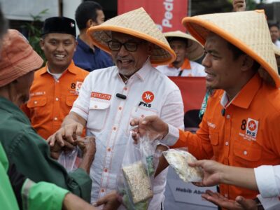 Ketua DPP PKS Bidang Tani dan Nelayan, Riyono Caping dan Presiden PKS Ahmad Syaikhu dalam aksi berbagi 1.000 paket sayuran dan 300 paket ikan asin kepada masyarakat di sekitar kantor DPTP PKS, Jakarta Selatan, Rabu (19/3/2025).