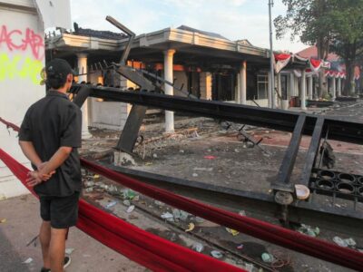 Warga saat melihat puing-puing Gedung Grahadi yang menjadi korban pembakaran oleh massa.