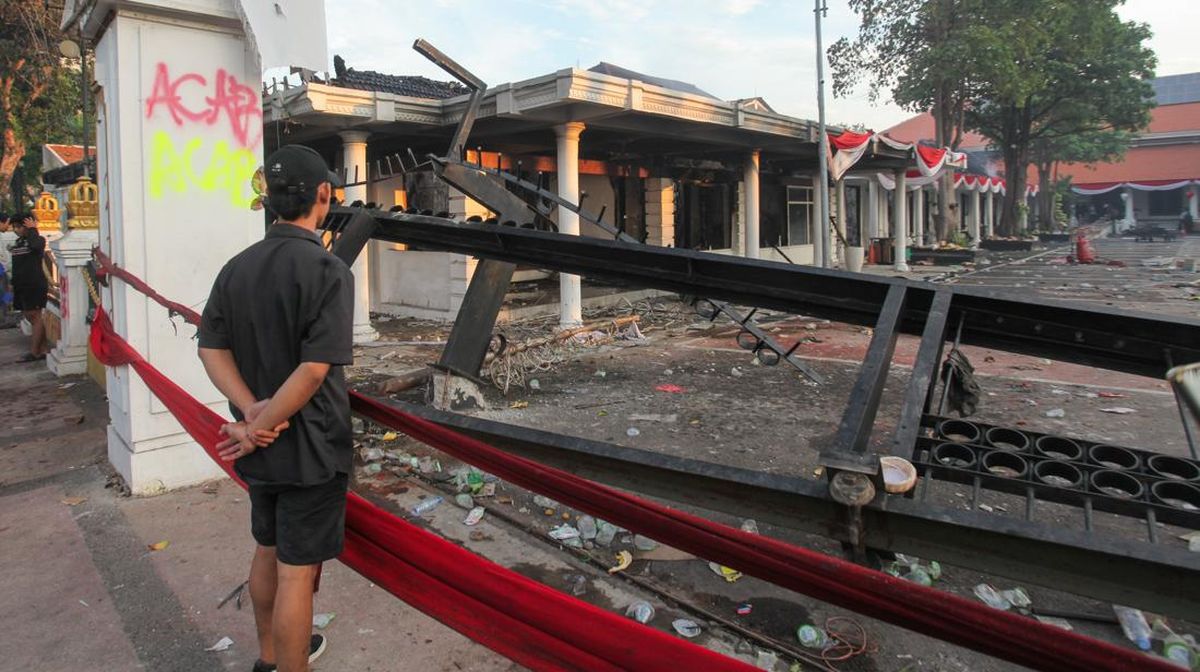 Warga saat melihat puing-puing Gedung Grahadi yang menjadi korban pembakaran oleh massa.